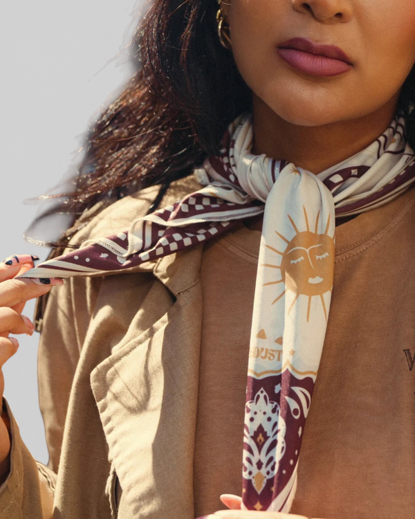 Baffle Haus Moon Rider scarf in beige with brown mystical tiger and celestial prints worn around a woman's neck.