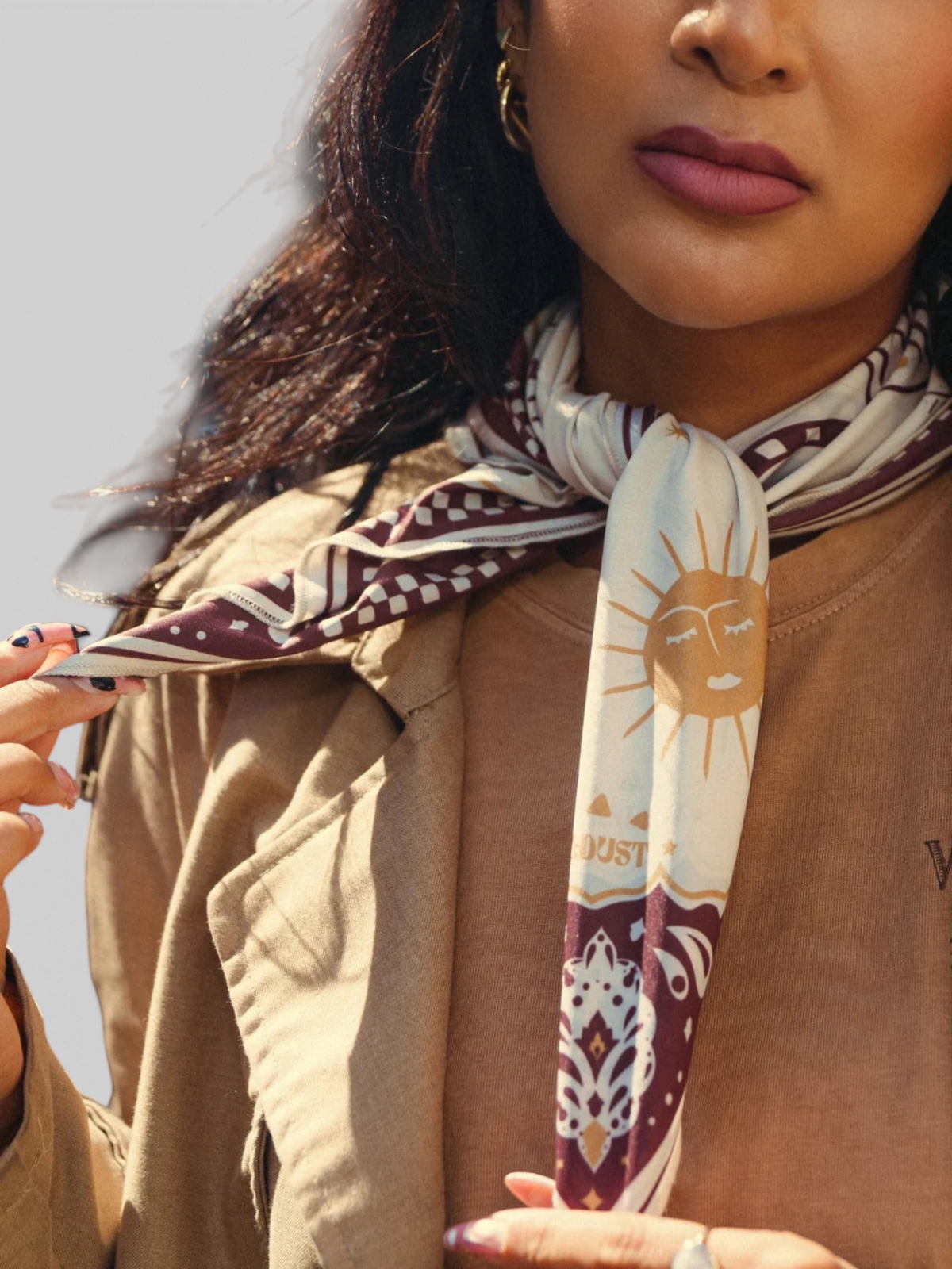 Baffle Haus Moon Rider scarf in beige with brown mystical tiger and celestial prints worn around a woman's neck.