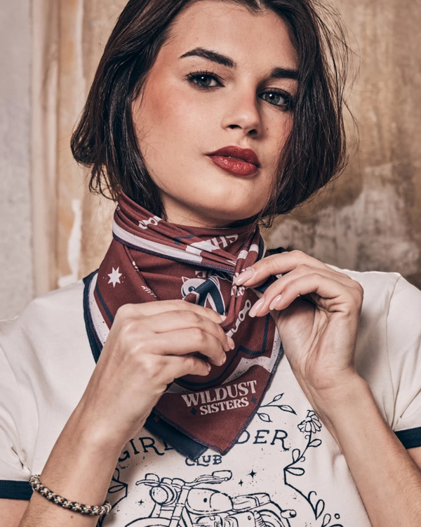 Baffle Haus Victory motorcycle scarf in blue and terracotta with retro racing graphics worn as a neck bandana