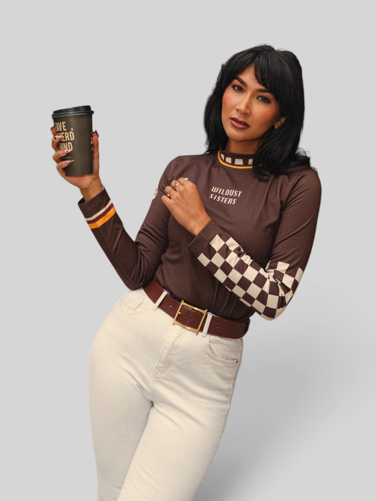 Baffle Haus brown long-sleeve Lycra top with vintage racing-inspired checkered sleeves and Wildust Sisters graphic.