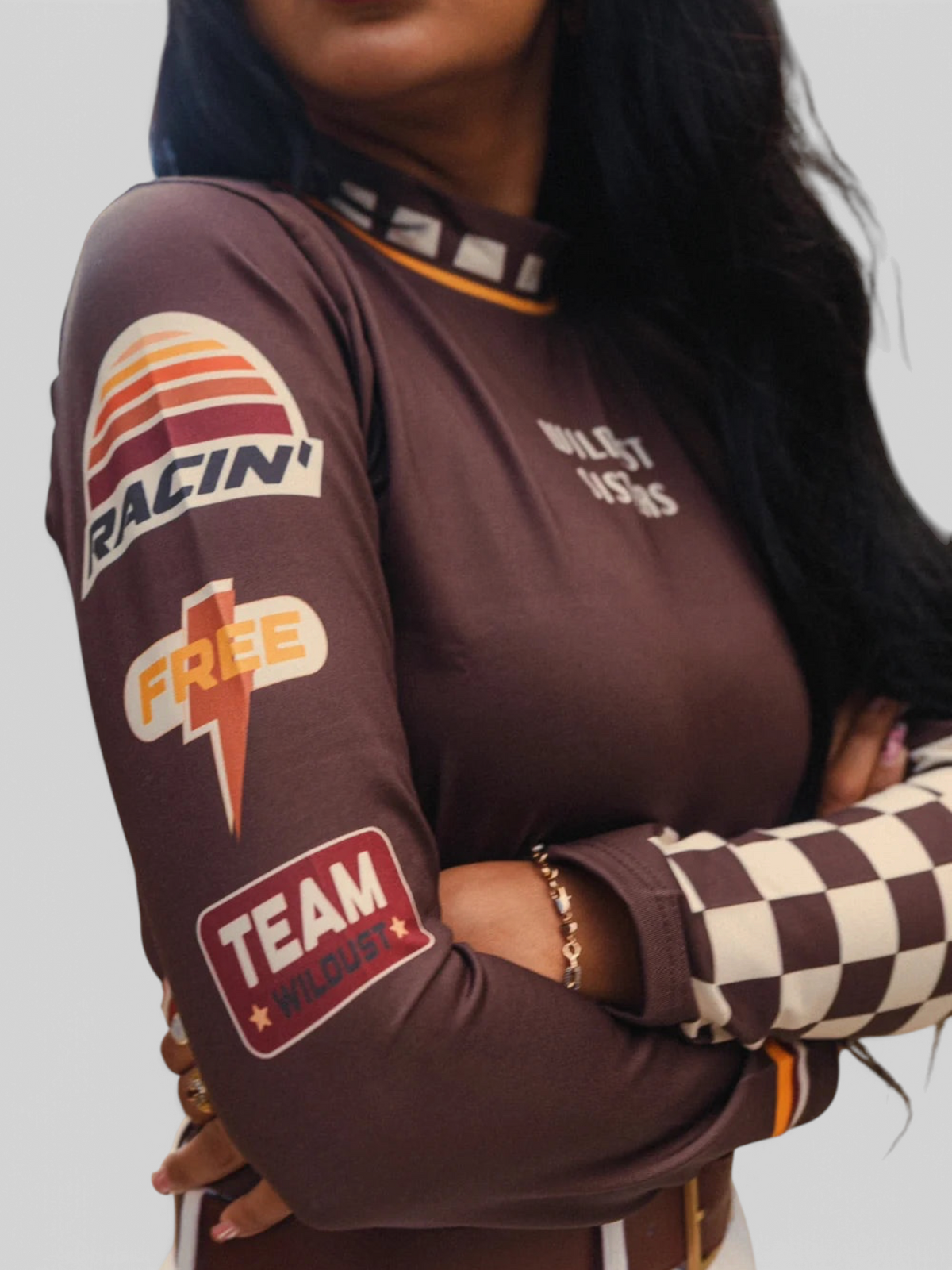 Baffle Haus brown long sleeve Lycra racing top with vintage-inspired patches and checkered cuffs on a model