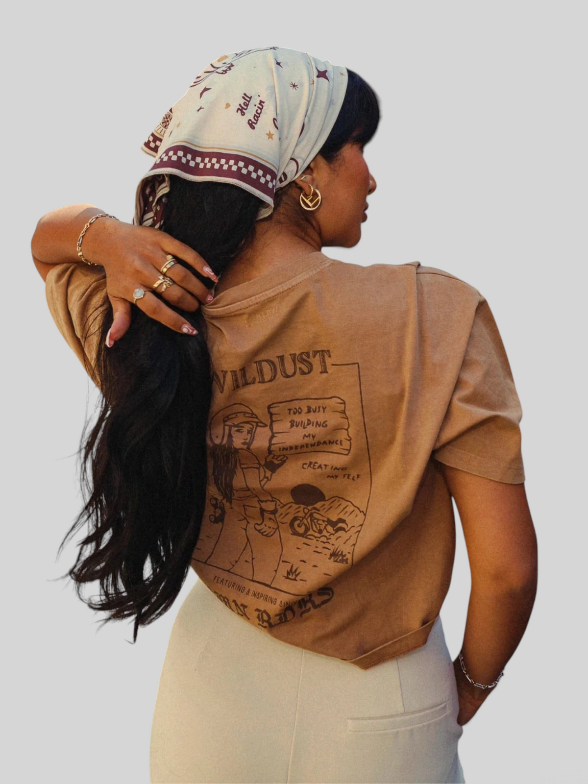 Baffle Haus khaki cropped cotton T-shirt with graphic print on back, worn by a woman with a patterned headscarf.